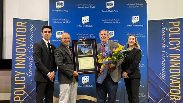 Dean Anil Deolalikar with students presenting the Policy Innovator Award to Randall Lewis