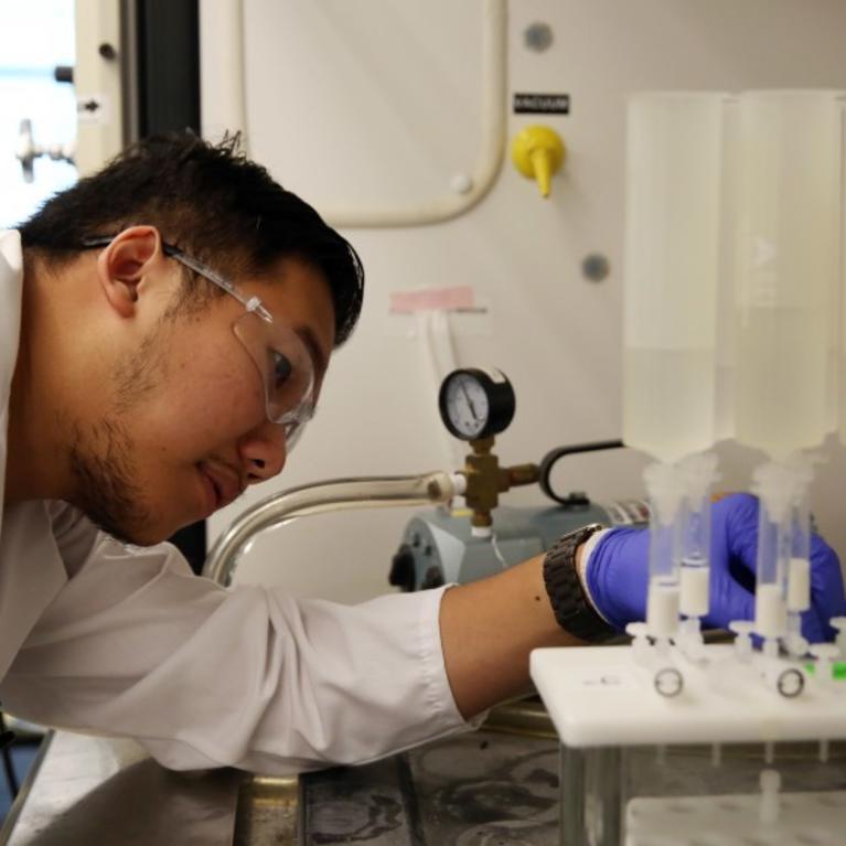 Twan Nguyen checks a machine testing surface water for PFAS compounds at the Orange County Water District. (Dania Maxwell / Los Angeles Times)