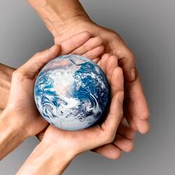 four hands holding small globe of the earth