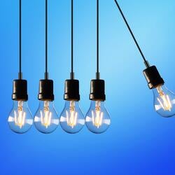 Four light bulbs hanging next to each other with a fifth swinging to hit the rest