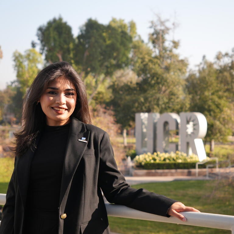 Dean's Ambassador Munazza Khalid standing in front of the UCR sign