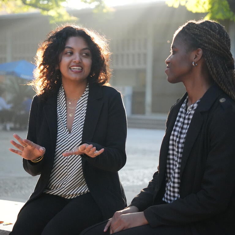 two female students talking on a bench