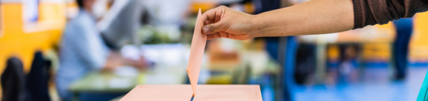 Woman dropping a ballot into a ballot box