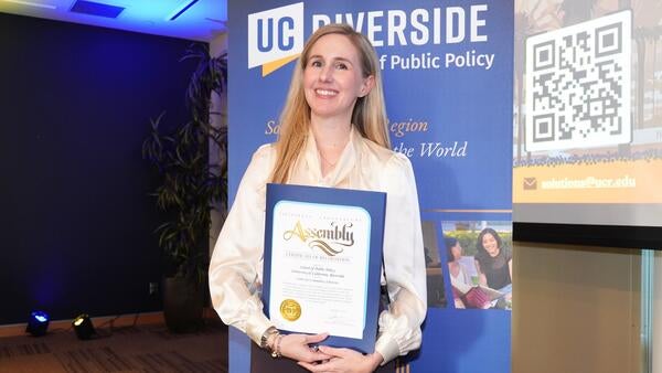 Justine Ross holding the certificate for the new research center