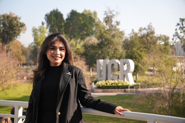 Dean's Ambassador Munazza Khalid standing in front of the UCR sign
