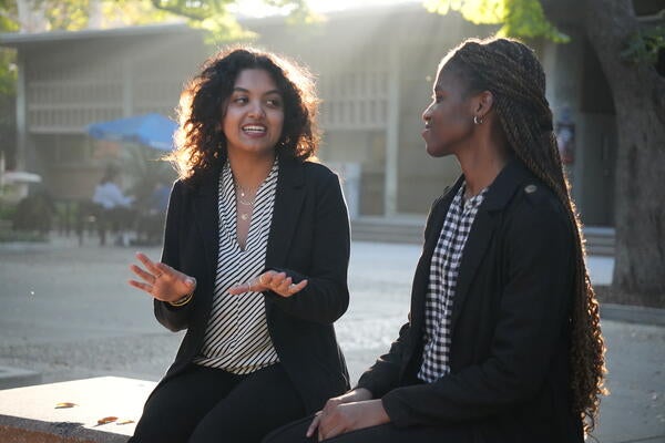 two female students talking on a bench